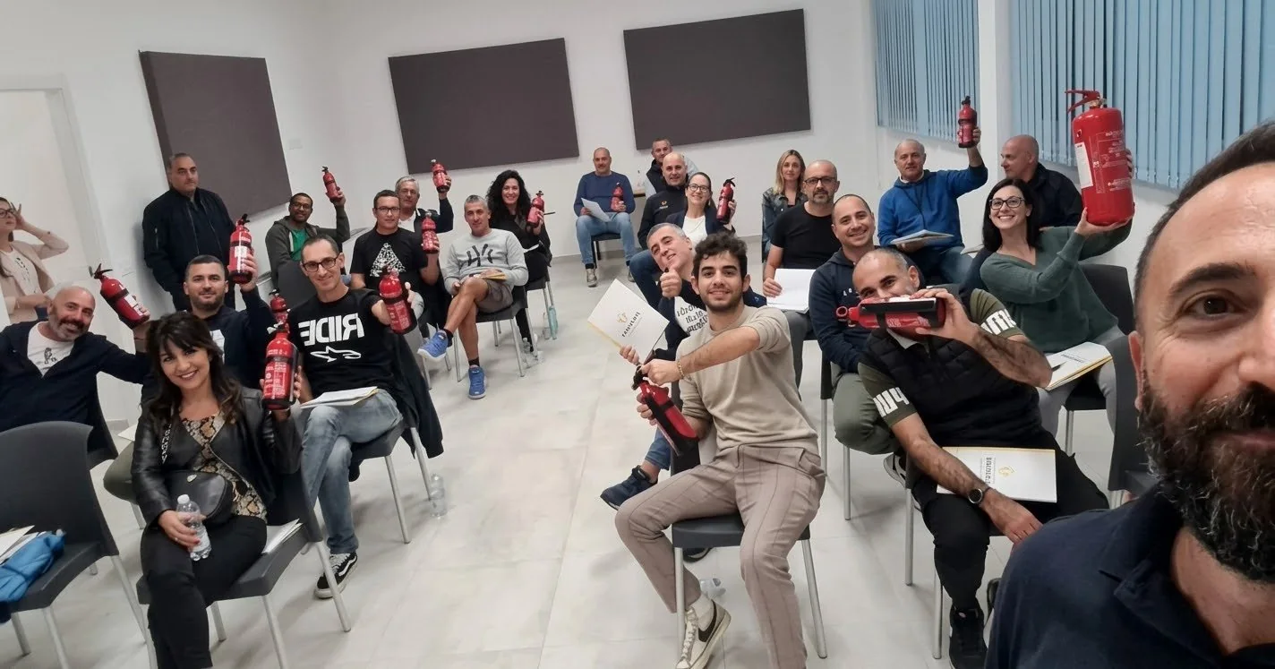 Una classe Finasser durante un corso antincendio: i partecipanti in aula con gli estintori