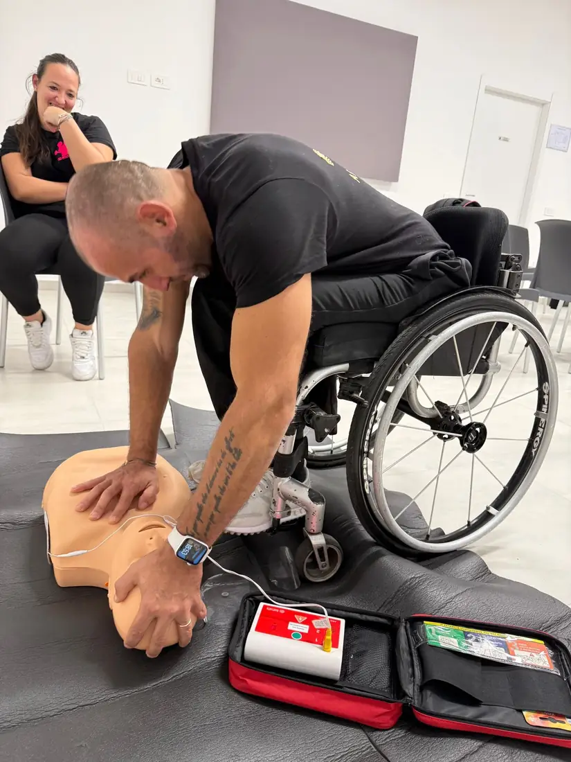 Un partecipante esegue il massaggio cardiaco su un manichino con il defibrillatore didattico