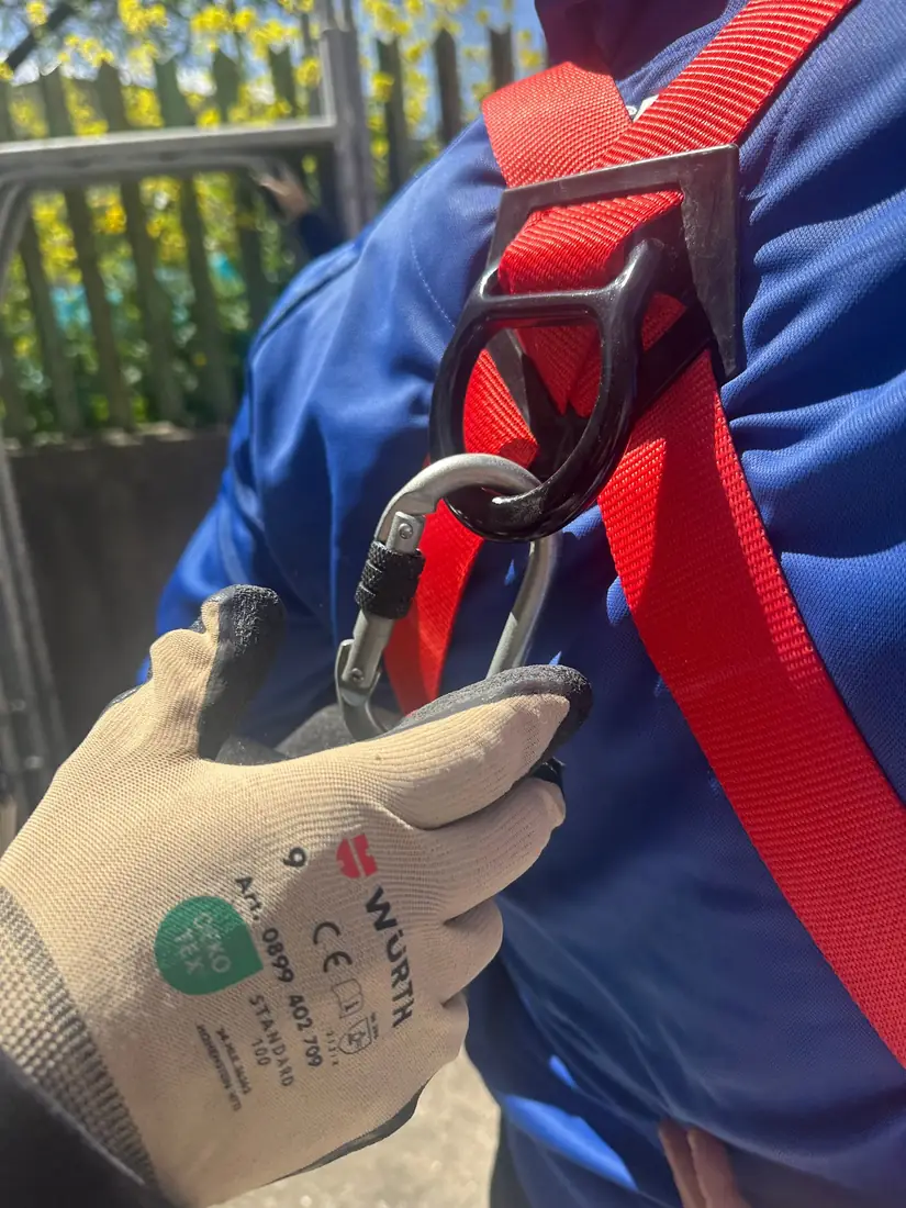 Un guanto da lavoro aggancia il moschettone all’imbracatura anticaduta